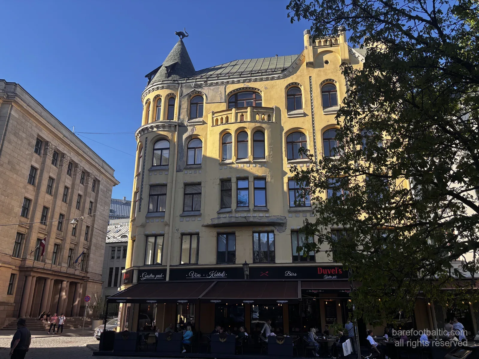 Das Katzenhaus (Kaķu nams) an der Meistaru iela in der Rigaer Altstadt, mit seiner gelben Jugendstilfassade und der Bronzekatze auf dem Eckt&uuml;rmchen, Lettland.