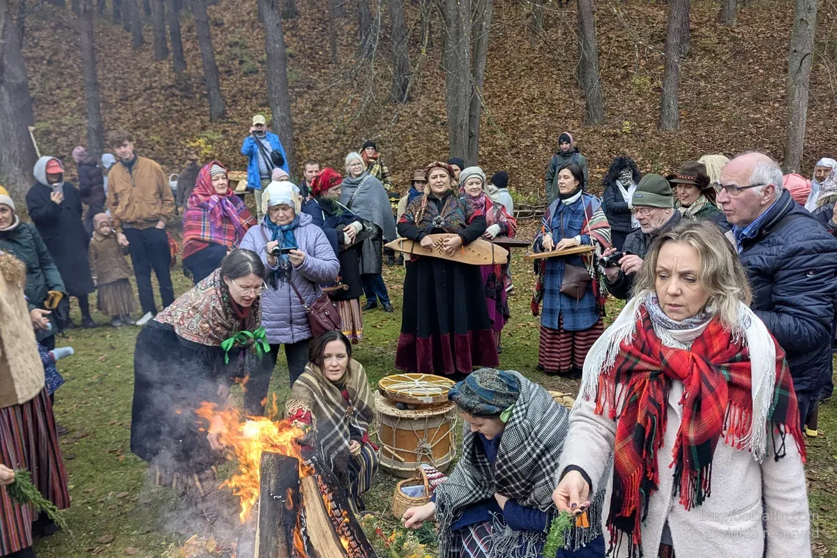 Besucher in Volkstracht am Mārtiņdiena-Lagerfeuer im lettischen Ethnographischen Freilichtmuseum, Riga.