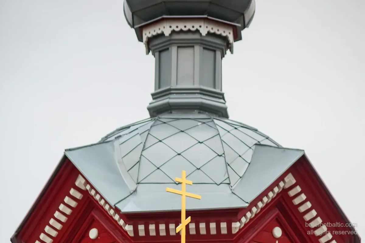 Eine hölzerne orthodoxe Kirche mit Zwiebelturm und dem dreibalkigen orthodoxen Kreuz — Lettland.