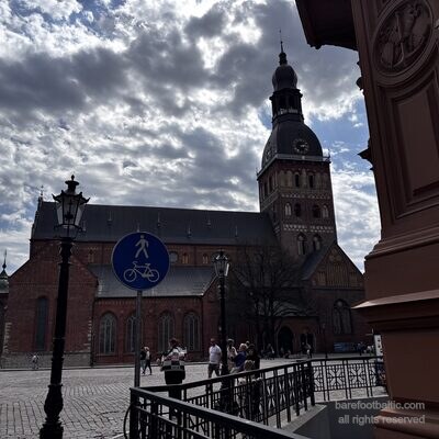 Der Dom zu Riga an einem bew&ouml;lkten Fr&uuml;hlingstag mit einem Fu&szlig;g&auml;ngerschild im Vordergrund, Lettland