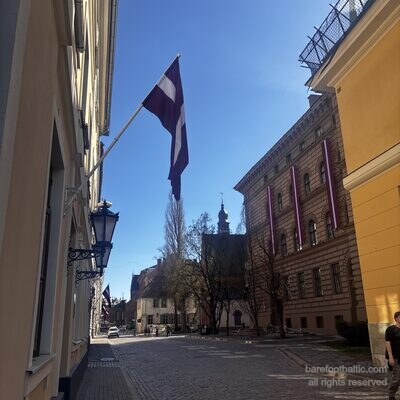 Pflastersteine der Jēkaba iela mit Saeima und Spitzturm der Jakobskathedrale voraus, Riga, Lettland
