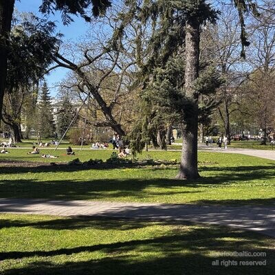 Menschen sitzen im Fr&uuml;hling auf dem Rasen in Vērmanes dārzs, Riga, Lettland