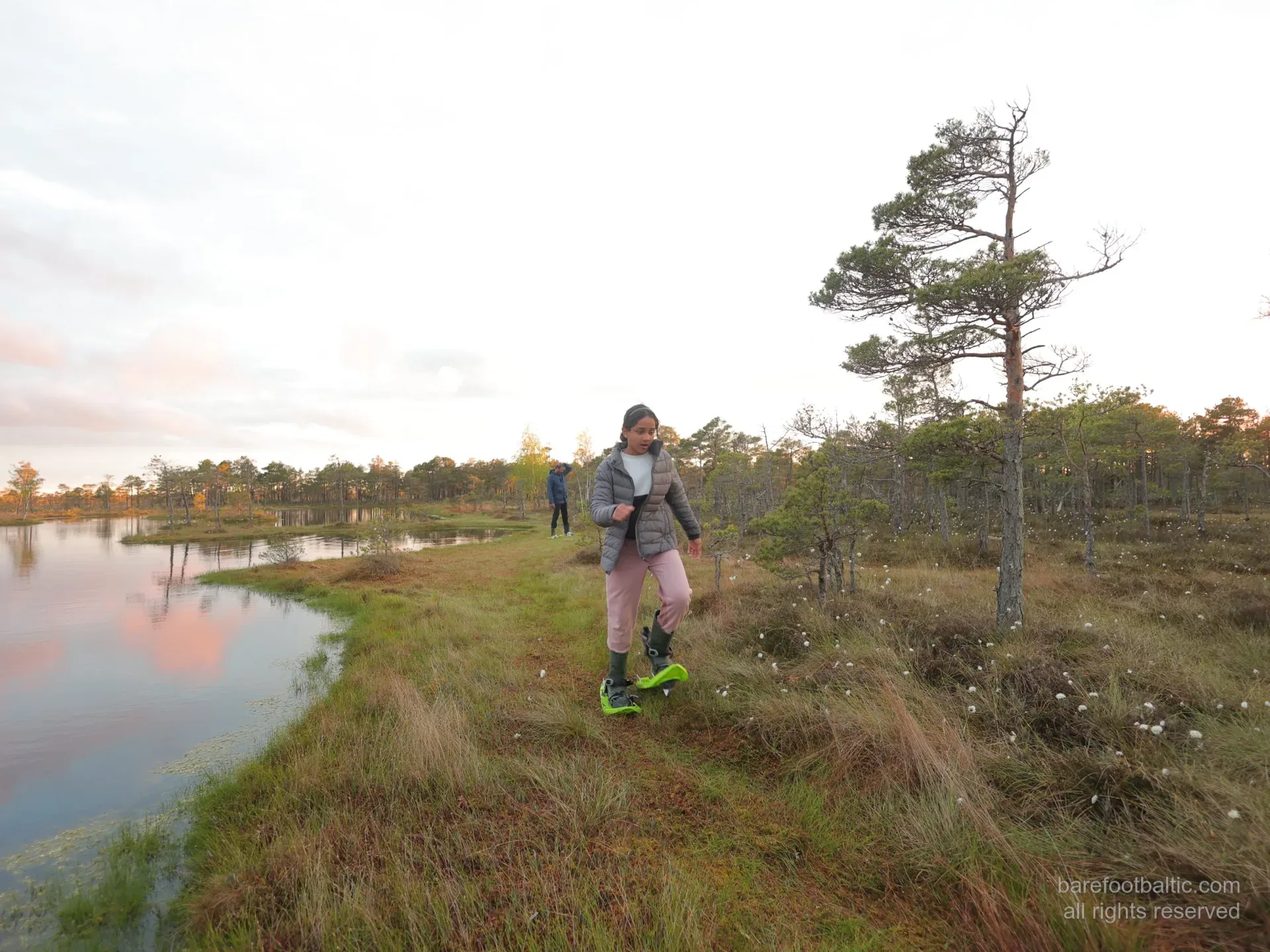 Guests in bog shoes beside a Kemeri bog pool